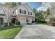 Two-story townhouse with a brick-accented driveway, garages, and a beautifully landscaped front yard at 558 Pinebranch Cir, Winter Springs, FL 32708