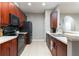 Well-maintained kitchen featuring dark wood cabinetry, black appliances, tile backsplash, and neutral countertops at 558 Pinebranch Cir, Winter Springs, FL 32708