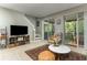 A comfortable living room with tile flooring, a cream-colored chair, and a slider to the porch at 558 Pinebranch Cir, Winter Springs, FL 32708