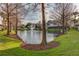 Community pond with a fountain surrounded by lush landscaping and bare trees during the winter at 558 Pinebranch Cir, Winter Springs, FL 32708