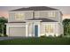Charming two-story home featuring a blue front door, neutral siding, and attached two-car garage at 5604 Wood Bridge Pl, St Cloud, FL 34771