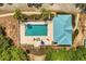 Aerial shot of a community pool with lounge chairs, umbrellas, and lush landscaping at 581 Hollingshead Loop, Davenport, FL 33896