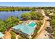 Aerial view of a community pool with a lake in the background at 581 Hollingshead Loop, Davenport, FL 33896