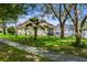 Spacious backyard with lush lawn, mature trees, and screened in patio at 581 Hollingshead Loop, Davenport, FL 33896