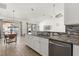 Modern kitchen with stainless steel dishwasher, granite countertops, and living room view at 581 Hollingshead Loop, Davenport, FL 33896