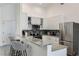 Modern kitchen with granite countertops, stainless steel appliances, breakfast bar, and white cabinetry at 581 Hollingshead Loop, Davenport, FL 33896