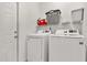 Bright laundry room with a washer, dryer, wire shelving, and a gray basket at 581 Hollingshead Loop, Davenport, FL 33896