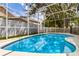 Swimming pool with screened-in enclosure and views of trees at 581 Hollingshead Loop, Davenport, FL 33896