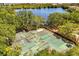 Aerial view of community tennis courts near a lake offering a scenic and active recreational space at 581 Hollingshead Loop, Davenport, FL 33896