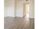 Well-lit bedroom with gray wood-look floors and neutral walls that leads into ensuite bathroom at 6021 Village Cir # 6021, Orlando, FL 32822