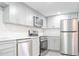 Bright kitchen featuring stainless steel appliances, subway tile backsplash and light gray cabinetry at 6021 Village Cir # 6021, Orlando, FL 32822