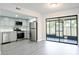 Open kitchen with stainless steel appliances, gray cabinets and new gray laminate flooring throughout at 6021 Village Cir # 6021, Orlando, FL 32822