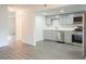 Modern kitchen with stainless steel appliances, gray cabinets, and new gray laminate flooring throughout at 6021 Village Cir # 6021, Orlando, FL 32822