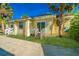 Quaint yellow home with a front porch, large sliding glass door, and a well-manicured lawn at 611 Sanford Ave, Sanford, FL 32771