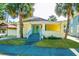 Charming yellow bungalow with a quaint porch, blue door, and mature palm trees at 611 Sanford Ave, Sanford, FL 32771