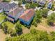 Aerial view of a charming two-story home featuring a well-maintained lawn and mature trees in a suburban neighborhood at 6807 Habitat Dr, St Cloud, FL 34773