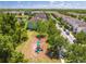 Aerial view of a charming two-story home near a playground and mature trees in a well-kept suburban neighborhood at 6807 Habitat Dr, St Cloud, FL 34773