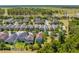 Aerial view of a two-story home in a suburban neighborhood with mature trees and well-maintained lawns on a sunny day at 6807 Habitat Dr, St Cloud, FL 34773