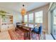 Stylish dining area featuring a wooden table, colorful rug and adjacent shelving for storage at 6807 Habitat Dr, St Cloud, FL 34773