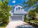 Charming two-story home featuring a gray garage, white trim, and well-manicured landscaping at 6807 Habitat Dr, St Cloud, FL 34773
