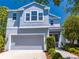 Charming two-story home featuring a gray garage, yellow door, and well-manicured landscaping at 6807 Habitat Dr, St Cloud, FL 34773