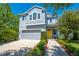 Charming two-story home featuring a gray garage, yellow door, and well-manicured landscaping at 6807 Habitat Dr, St Cloud, FL 34773