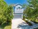 Charming two-story home featuring a gray garage, white trim, and well-manicured landscaping at 6807 Habitat Dr, St Cloud, FL 34773
