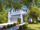 Charming two-story home featuring a gray garage, yellow door, and well-manicured landscaping at 6807 Habitat Dr, St Cloud, FL 34773