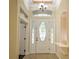 Bright foyer featuring tile floors, a decorative front door, and an arched transom window at 7167 Winding Lake Cir, Oviedo, FL 32765