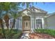Inviting front entrance with a decorative glass door, flanked by elegant columns and manicured landscaping at 7167 Winding Lake Cir, Oviedo, FL 32765