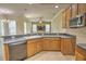 Open kitchen featuring wood cabinets, a breakfast bar, and black appliances at 7167 Winding Lake Cir, Oviedo, FL 32765