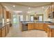Open kitchen with wood cabinetry and view of the breakfast nook and living area at 7167 Winding Lake Cir, Oviedo, FL 32765
