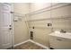 Functional laundry room with utility sink, wire shelving, and tile flooring at 7167 Winding Lake Cir, Oviedo, FL 32765