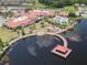 Aerial view of community clubhouse with pool, waterfront pier, lush landscaping, and surrounding trees at 725 High Vista Dr, Davenport, FL 33837