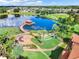 Overhead aerial view of a lake with a dock, gardens, and palm trees at 725 High Vista Dr, Davenport, FL 33837