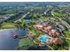 Aerial view of community clubhouse, pool, tennis courts, parking, and waterfront with surrounding homes and trees at 725 High Vista Dr, Davenport, FL 33837