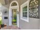 Elegant front door with decorative glass and side window, enhanced by decorative ironwork and plants at 725 High Vista Dr, Davenport, FL 33837
