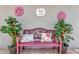 Cozy outdoor bench with floral pillows and decorative plants, creating a welcoming porch setting at 725 High Vista Dr, Davenport, FL 33837