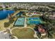 Aerial view of community tennis courts and clubhouse surrounded by beautiful landscaping and neighborhood homes at 725 High Vista Dr, Davenport, FL 33837
