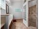 Bathroom featuring a walk-in shower, dual vanities, and decorative glass block windows at 7264 Hawksnest Blvd, Orlando, FL 32835