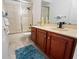 Bathroom with a walk-in shower with glass doors, wooden vanity, and neutral countertops at 7264 Hawksnest Blvd, Orlando, FL 32835