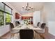 Open dining area featuring a modern chandelier and an adjacent kitchen and breakfast bar at 7264 Hawksnest Blvd, Orlando, FL 32835