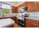 Well-equipped kitchen featuring wood cabinetry, stainless steel appliances, and ample counter space at 7264 Hawksnest Blvd, Orlando, FL 32835