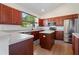 Well-lit kitchen with stainless appliances, wood cabinets, and island at 7264 Hawksnest Blvd, Orlando, FL 32835