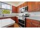 Kitchen with stainless steel appliances, wood cabinets, and breakfast bar at 7264 Hawksnest Blvd, Orlando, FL 32835