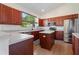 Well-appointed kitchen with stainless steel appliances, cherry wood cabinets, and bright countertops at 7264 Hawksnest Blvd, Orlando, FL 32835
