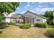 An exterior view of a lovely screened-in porch and backyard with mature shrubs at 7264 Hawksnest Blvd, Orlando, FL 32835