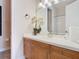 Bathroom featuring a wood vanity, white countertop, mirror, and a shower over the tub at 7409 Excitement Dr, Reunion, FL 34747