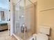 Modern bathroom features tiled shower with glass door, toilet and vanity at 7409 Excitement Dr, Reunion, FL 34747