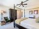 Well-lit carpeted bedroom with ceiling fan, four-poster bed, wardrobe, and coordinated wall art at 7409 Excitement Dr, Reunion, FL 34747